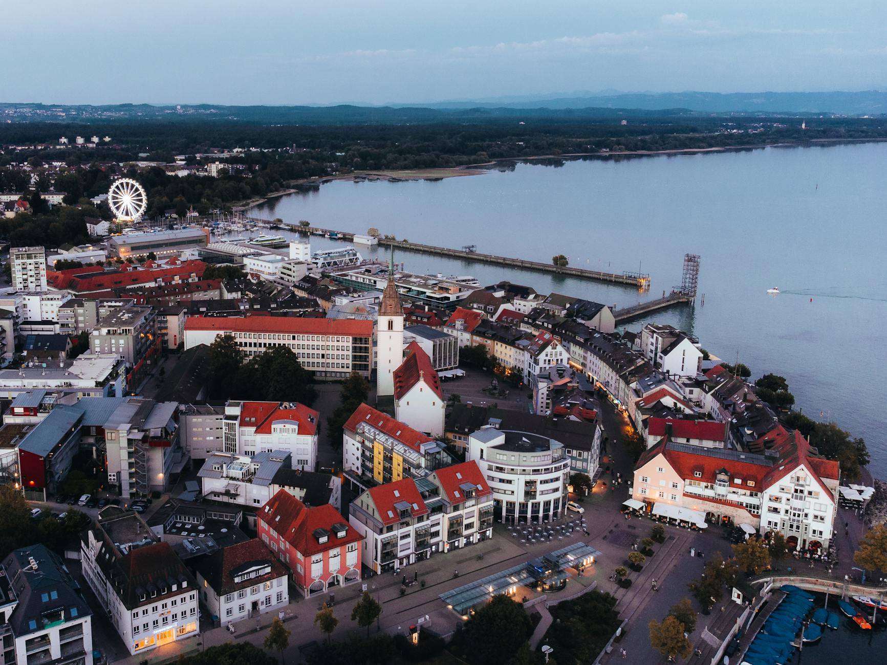 A stunning aerial view of Friedrichshafen by Lake Constance, showcasing urban architecture and a ferris wheel.