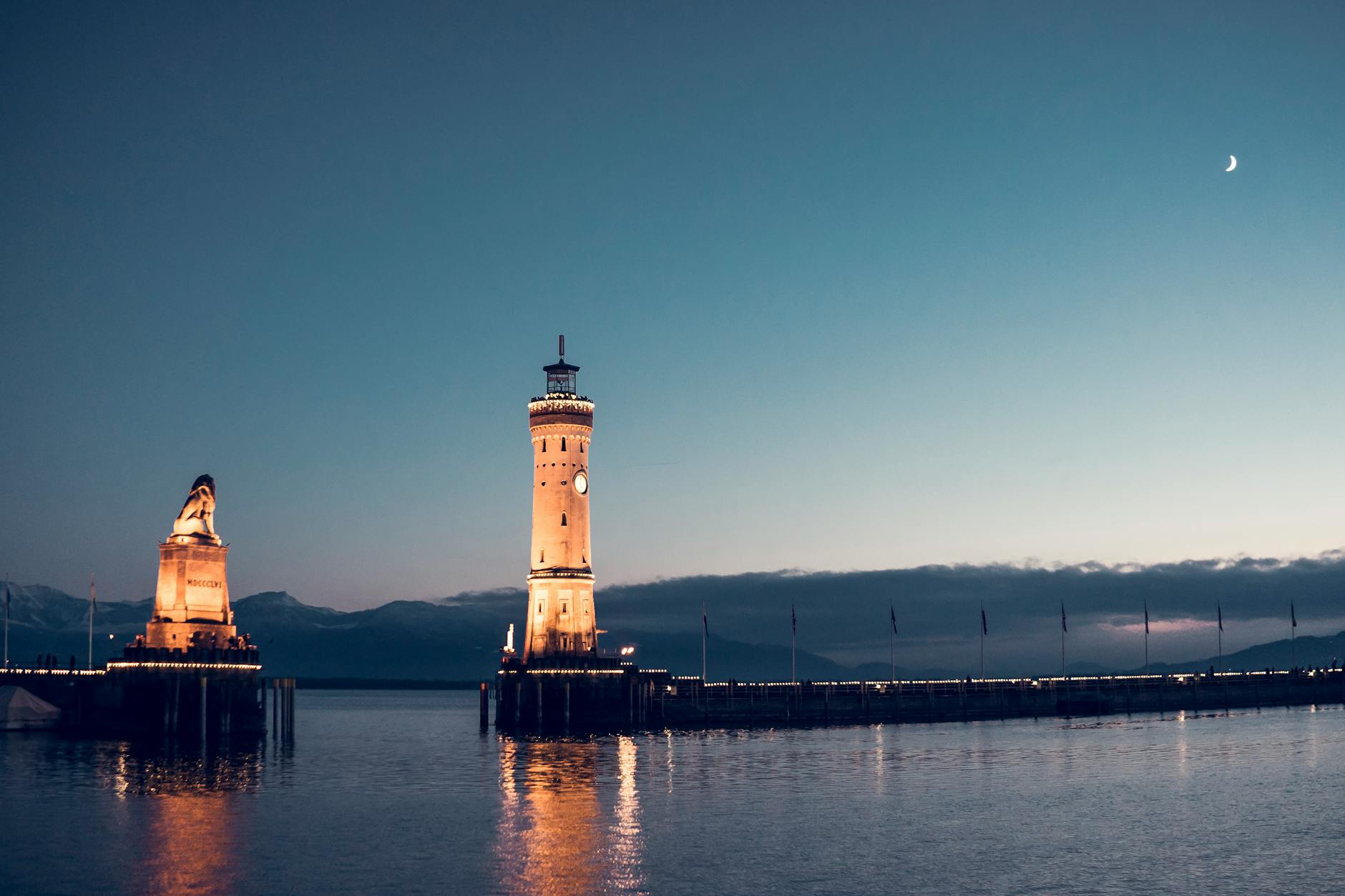 Stunning view of Lindau Lighthouse and Bavarian Lion at dusk on Lake Constance, Germany.