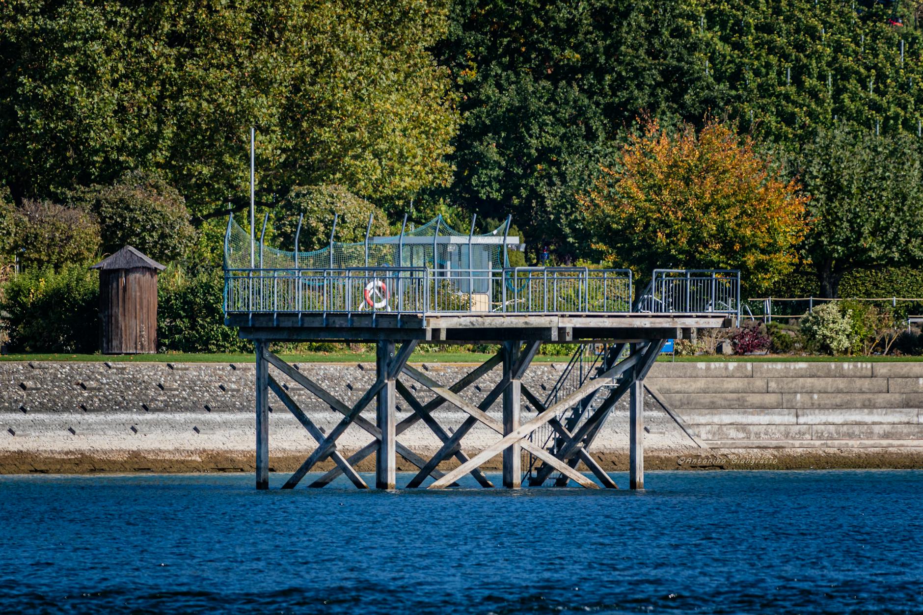 A picturesque pier at Lake Constance in Konstanz, Germany surrounded by lush greenery.