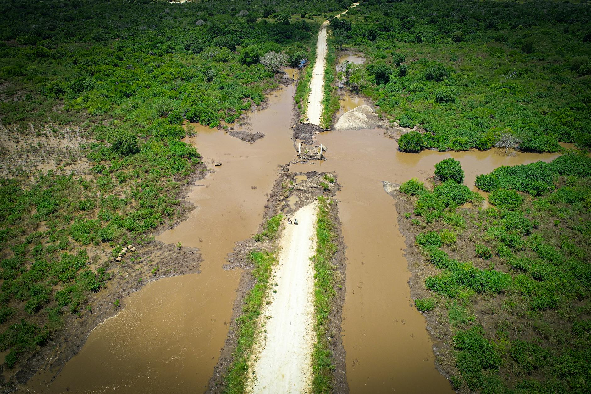 Aerial shot of a muddy river and surrounding green landscape in Bagamoyo, Tanzania, showcasing nature's beauty.