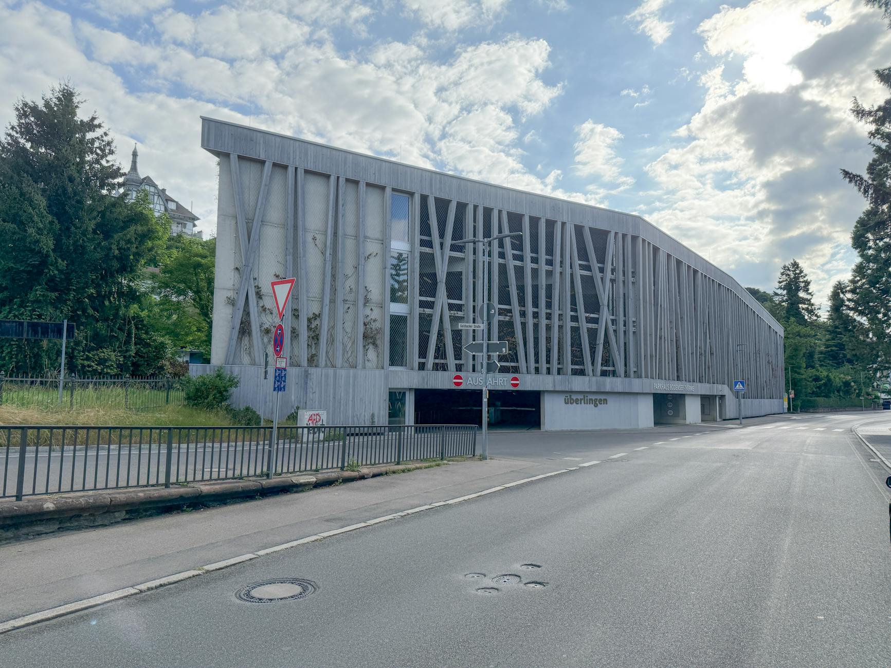 Contemporary parking structure in a European city with blue sky and minimal traffic.