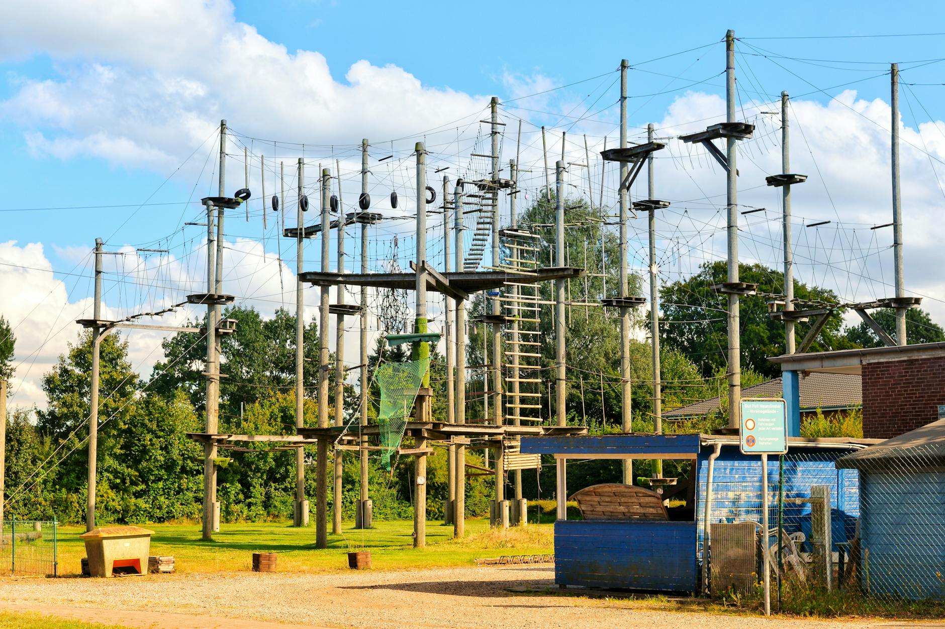Outdoor ropes course with various obstacles in Neumünster, offering sunny day adventure activities.
