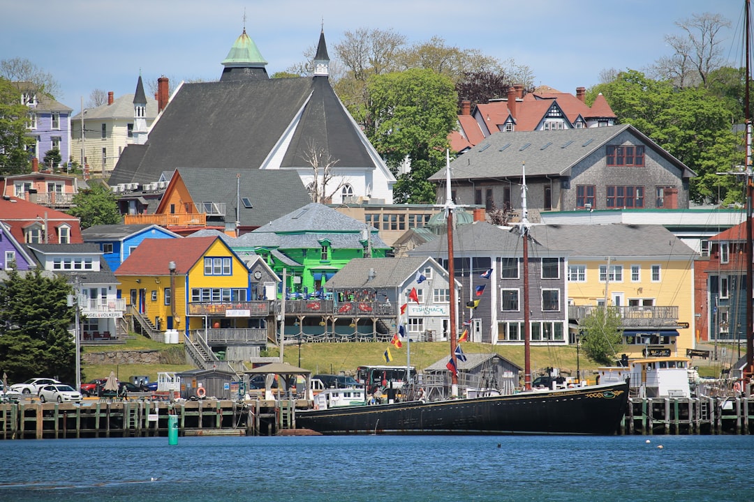 Colorful buildings line a waterfront with a historic ship.