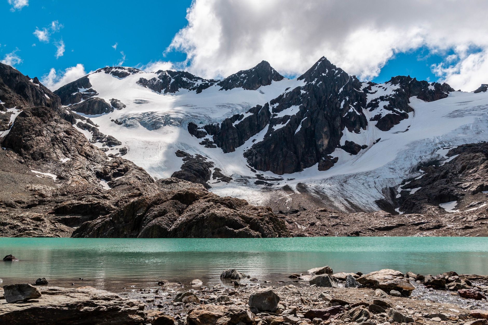 A breathtaking view of snow-covered mountains and a turquoise lagoon in Ushuaia, Argentina.