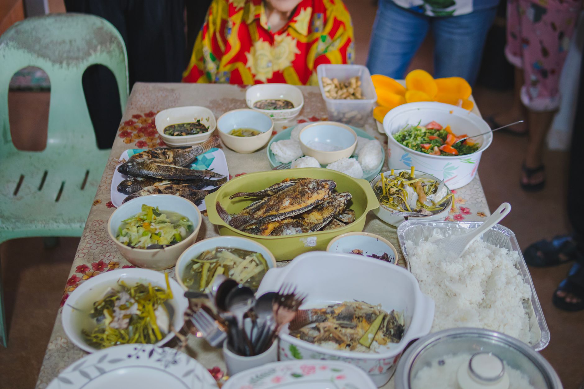 A vibrant spread of traditional Filipino dishes including fried fish and assorted side dishes on a table.