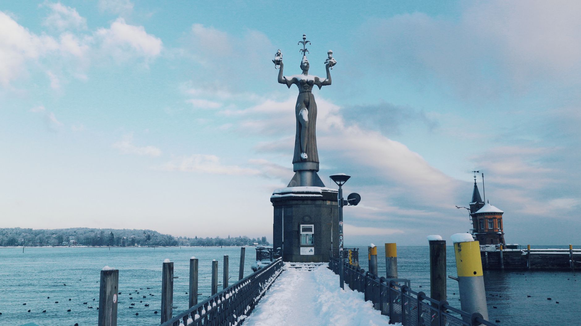 The majestic Imperia statue in Konstanz, Germany, standing proudly with a snow-covered harbor backdrop.